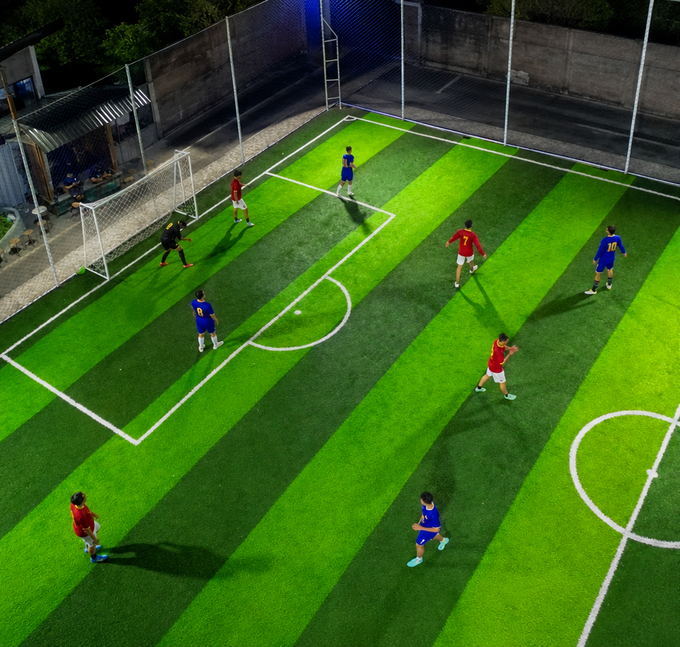 A floodlit evening match under way on the mini soccer pitch at Dupak 36.